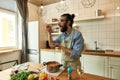 Italian man, chef cook tasting soup while preparing a meal in the kitchen. Cooking at home, Italian cuisine Royalty Free Stock Photo