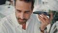 Italian man listening audio use phone at cafe closeup. Executive drinking coffee Royalty Free Stock Photo