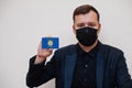 Italian man wear black formal and protect face mask, hold Calabria flag card isolated on white background. Italy regions