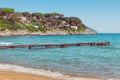 Italian maritime coast of the Island of Elba with rocky cliff ridge, perched house and boardwalk. Sea, trees and rocks in Italy in