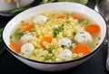 Italian meatball soup and Stelline pasta in bowl on black table. Royalty Free Stock Photo