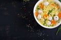 Italian meatball soup and Stelline gluten free pasta in bowl on black table. Royalty Free Stock Photo