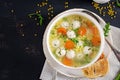 Italian meatball soup and Stelline pasta in bowl on black table. Royalty Free Stock Photo