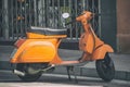 Italian orange Vespa Scooter parked on the road