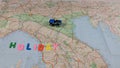 Italian paper travel geographical map with spinning toy car and the inscription holiday Royalty Free Stock Photo