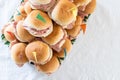 Italian party panini piled in stack in finger food style. Small panini sandwich with ham and salami. Italian food birthday party
