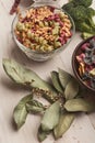 Italian pasta in bowls and laurel leaf on white wood Royalty Free Stock Photo