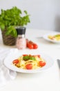 Italian pasta with cherry tomatoes, tomato sauce and cheese, garnished with a sprig of basil. Ready lunch or dinner Royalty Free Stock Photo