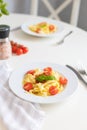 Italian pasta with cherry tomatoes, tomato sauce and cheese, garnished with a sprig of basil. Ready lunch or dinner Royalty Free Stock Photo