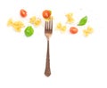 Italian pasta design. A fork with farfalle, basil, cherry tomatoes, salt and pepper, shot from the top