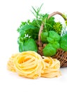 Italian pasta fettuccine nest with wicker basket green herbs