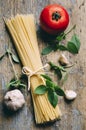 Italian pasta food ingredients on rustic wooden table from above. Top view of spaghetti, garlic, tomato and basil for bolognese Royalty Free Stock Photo