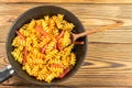 Italian pasta fusilli with tomato sauce and sausage in pan, wooden spoon on table, top view, space for text Royalty Free Stock Photo