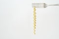 Italian pasta hanging from a silver fork, isolated on white background,free copy space Royalty Free Stock Photo