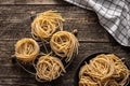 Italian pasta nest. Uncooked spaghetti nest on old wooden table