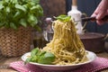 Italian pasta with pesto sauce and fresh basil. A delicious homemade dinner and a man`s hand with a fork in the frame. Photo in a Royalty Free Stock Photo