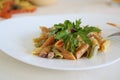 Italian pasta with pistachios in a triangular white plate