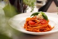 Italian pasta, pomodoro, bolognese. Tomato spaghetti with basil and cheese on a white plate, close-up. Royalty Free Stock Photo