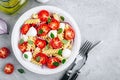 Italian pasta salad with tomatoes, mozzarella cheese, red onion and basil. Top view Royalty Free Stock Photo