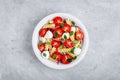 Italian pasta salad with tomatoes, mozzarella cheese, red onion and basil. Top view