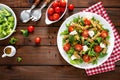 Italian pasta salad with wholegrain fusilli, fresh tomato, cheese, lettuce and broccoli on wooden rustic background Royalty Free Stock Photo