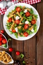 Italian pasta salad with wholegrain fusilli, fresh tomato, cheese, lettuce and broccoli on wooden rustic background Royalty Free Stock Photo
