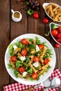 Italian pasta salad with wholegrain fusilli, fresh tomato, cheese, lettuce and broccoli on wooden rustic background Royalty Free Stock Photo