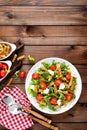 Italian pasta salad with wholegrain fusilli, fresh tomato, cheese, lettuce and broccoli on wooden rustic background Royalty Free Stock Photo