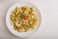 The Italian pasta with shrimp, pesto sauce, walnut on white plate on wooden table. Top view. Mediterranean cuisine Royalty Free Stock Photo