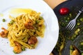 Italian pasta with shrimps on plate and rounded pan. Royalty Free Stock Photo