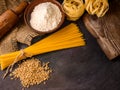 Italian pasta, spaghetti, fettuccine, wheat, rolling pin, flour on a textured background. Still life in a rustic style Royalty Free Stock Photo