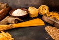 Italian pasta, spaghetti, fettuccine, wheat, rolling pin, flour on a textured background. Still life in a rustic style. Top view.