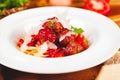 Italian pasta. Spaghetti with tomato sauce and meatballs on white plate with parmesan cheese, fresh parsley and tomatoes. Royalty Free Stock Photo