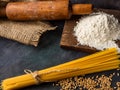 Italian pasta, spaghetti, wheat, rolling pin, flour on a textured background. Still life in a rustic style. Element for design Royalty Free Stock Photo