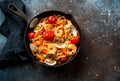 Italian pasta with tomato sauce, scallops and shrimps in a skillet Royalty Free Stock Photo