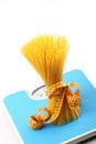 Italian pasta on white background with bathroom scale Royalty Free Stock Photo