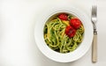 Italian Pasta with zucchini noodles with Avocado Sauce pesto and roasted tomato in white plate. Top view white