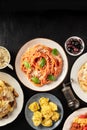 Italian pastas, spaghetti and ravioli, overhead flat lay shot on a black background Royalty Free Stock Photo