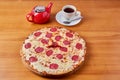 italian pepperoni pizza with red pepper on a wooden stand with tea and kettle Royalty Free Stock Photo