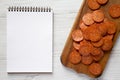 Italian Pepperoni Slices on a rustic wooden board, blank notepad on a white wooden background, top view. Flat lay, overhead, from Royalty Free Stock Photo