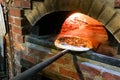 Italian pizza being baked in traditional wood flame fire oven