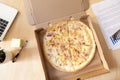 Italian pizza in cardboard box on work desk, top view Royalty Free Stock Photo