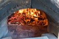 Italian pizza cooking in pizza oven over open flame Royalty Free Stock Photo
