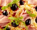 Italian pizza detail with olives, rocket and ham Royalty Free Stock Photo