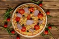 Italian pizza with ham, tomatoes, olives and basil on wooden table. Top view with copy space Royalty Free Stock Photo