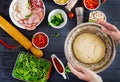 Italian pizza. Hands working with dough preparation pizza or pie making ingredients on table. Royalty Free Stock Photo