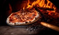 Italian pizza on long shovel, brick oven with open fire, background with copy space