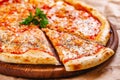 Italian Pizza Margherita with tomatoes and mozzarella cheese on wooden cutting board Royalty Free Stock Photo