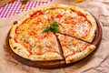 Italian Pizza Margherita with tomatoes and mozzarella cheese on wooden cutting board Royalty Free Stock Photo