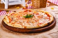 Italian Pizza Margherita with tomatoes and mozzarella cheese on wooden cutting board. Royalty Free Stock Photo